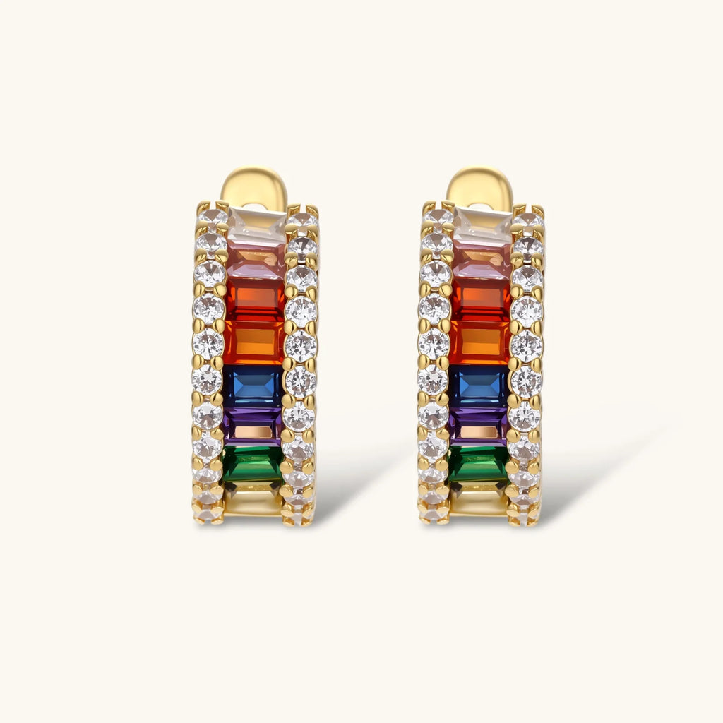 Gold-plated jewelry set featuring rainbow baguette-cut cubic zirconia stones in geometric design on cream background