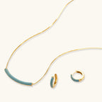 Azure Curve necklace and hoop earrings shown at an angle, with one hoop open