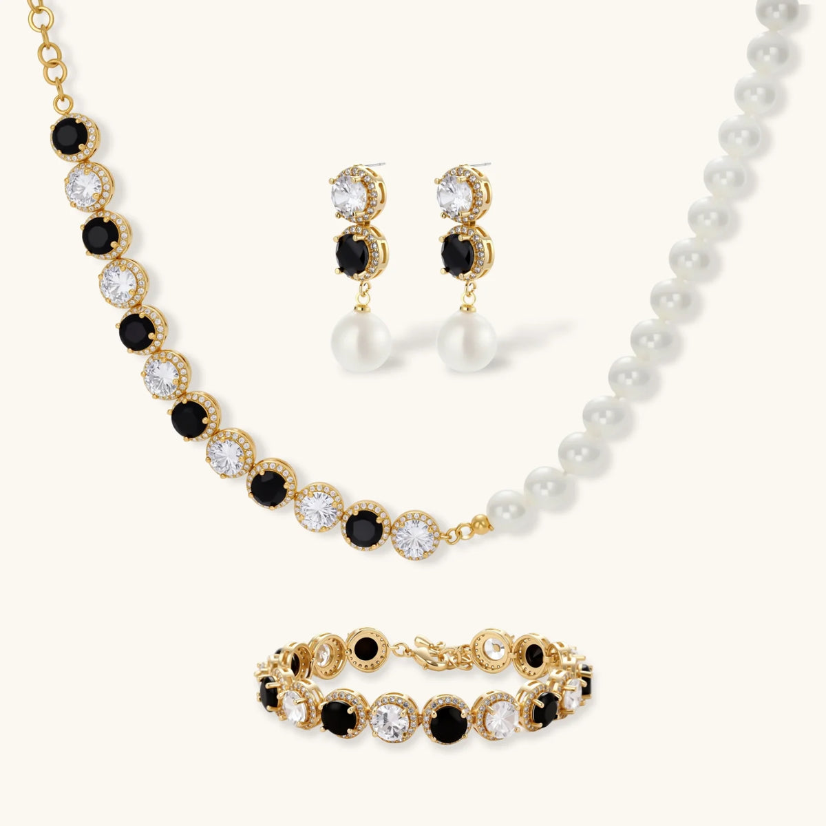 Gold-plated jewelry set with alternating black and clear cubic zirconia stones, featuring necklace, earrings and bracelet