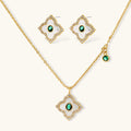 Emerald Bloom set: gold-tone pendant necklace and four-petal stud earrings with white inlay, oval green center stones and clear stone borders, front view