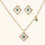 Emerald Bloom set: gold-tone pendant necklace and four-petal stud earrings with white inlay, oval green center stones and clear stone borders, front view
