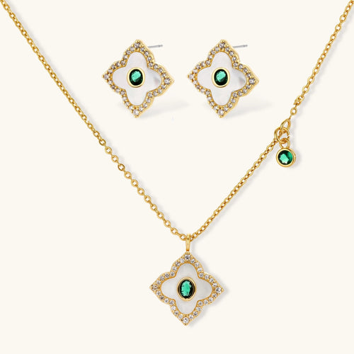 Emerald Bloom set: gold-tone pendant necklace and four-petal stud earrings with white inlay, oval green center stones and clear stone borders, front view