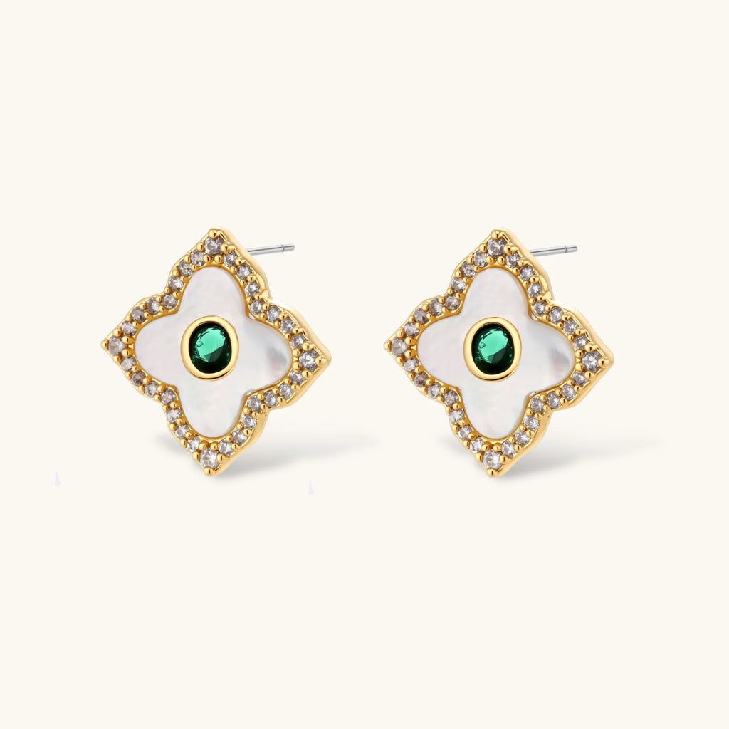 Close-up of the Emerald Bloom four-petal stud earrings with white inlay and oval green centers
