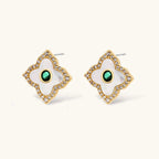 Close-up of the Emerald Bloom four-petal stud earrings with white inlay and oval green centers