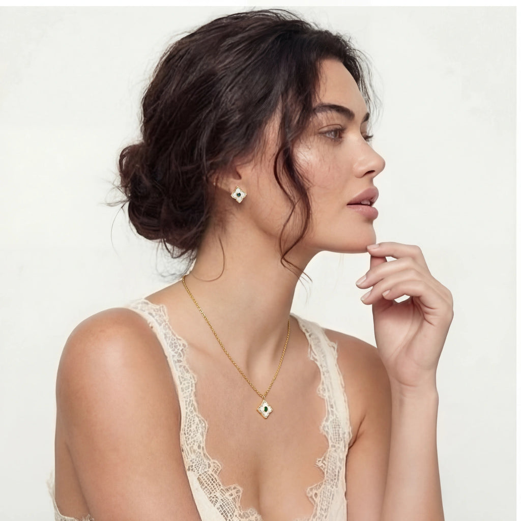 Side profile of a model in a lace top wearing the Emerald Bloom necklace and earrings