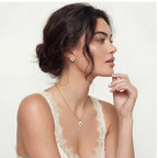 Side profile of a model in a lace top wearing the Emerald Bloom necklace and earrings