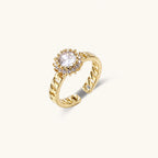Gold-plated adjustable ring with twisted chain band, central cubic zirconia stone surrounded by crystal halo on cream background