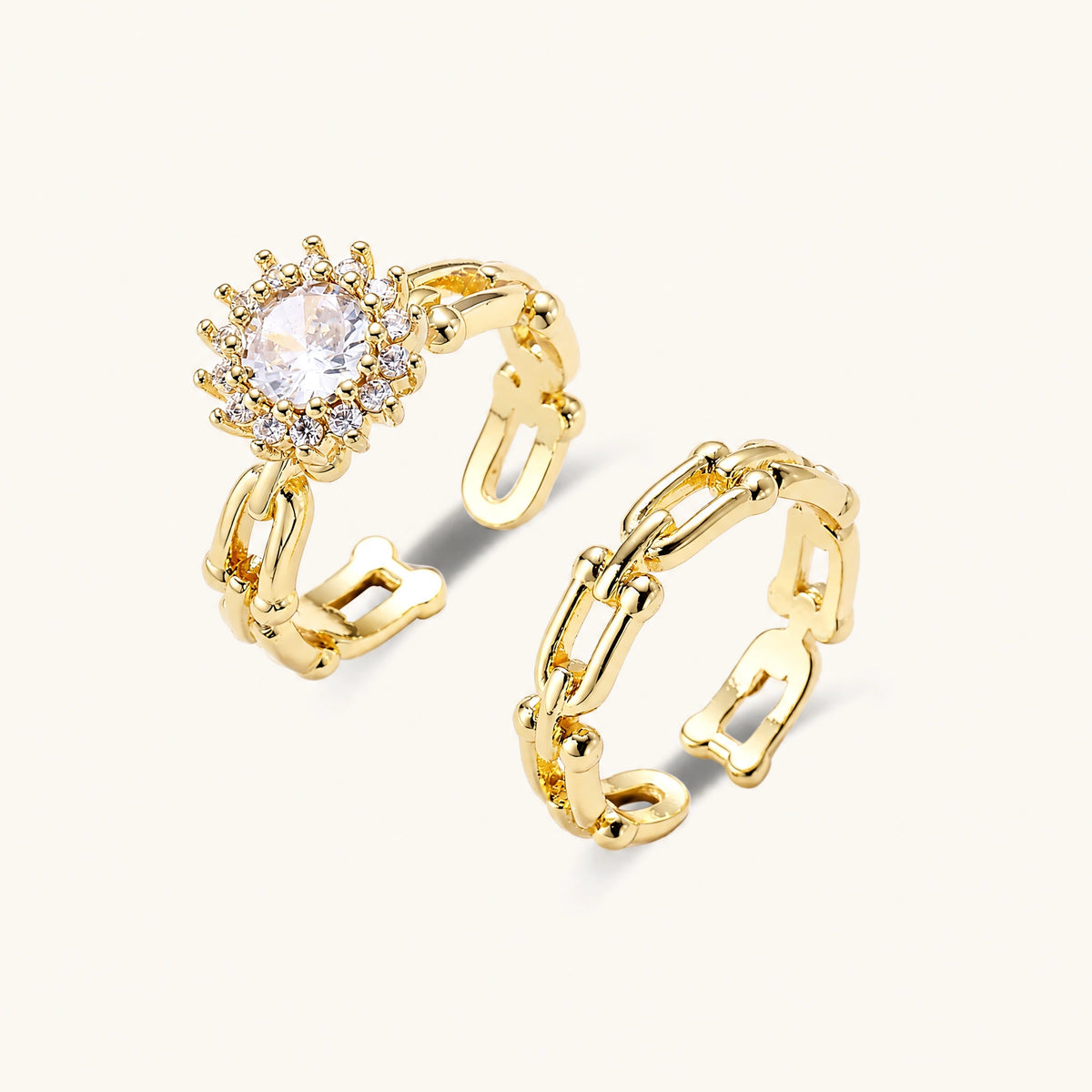 Two adjustable gold rings: chain-link band and halo-style ring with cubic zirconia stones on cream background