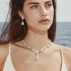 Model by the sea wearing the Celestial Cascade necklace and earrings