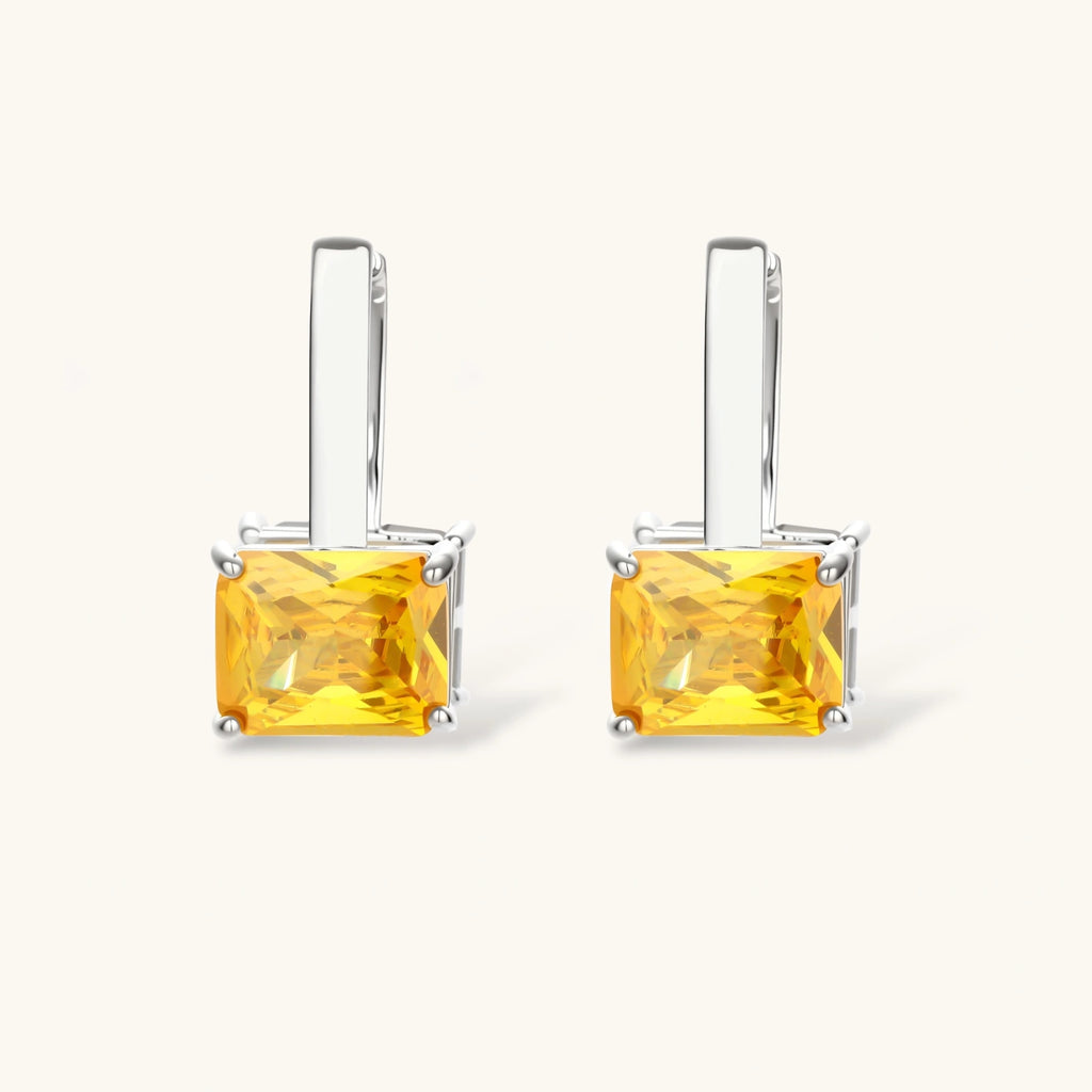 Front view of the Solar Duo drop hoop earrings with yellow and clear square stones
